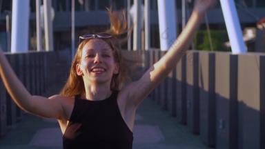 美丽的年轻的女孩跳舞行人桥相机慢运动视频
